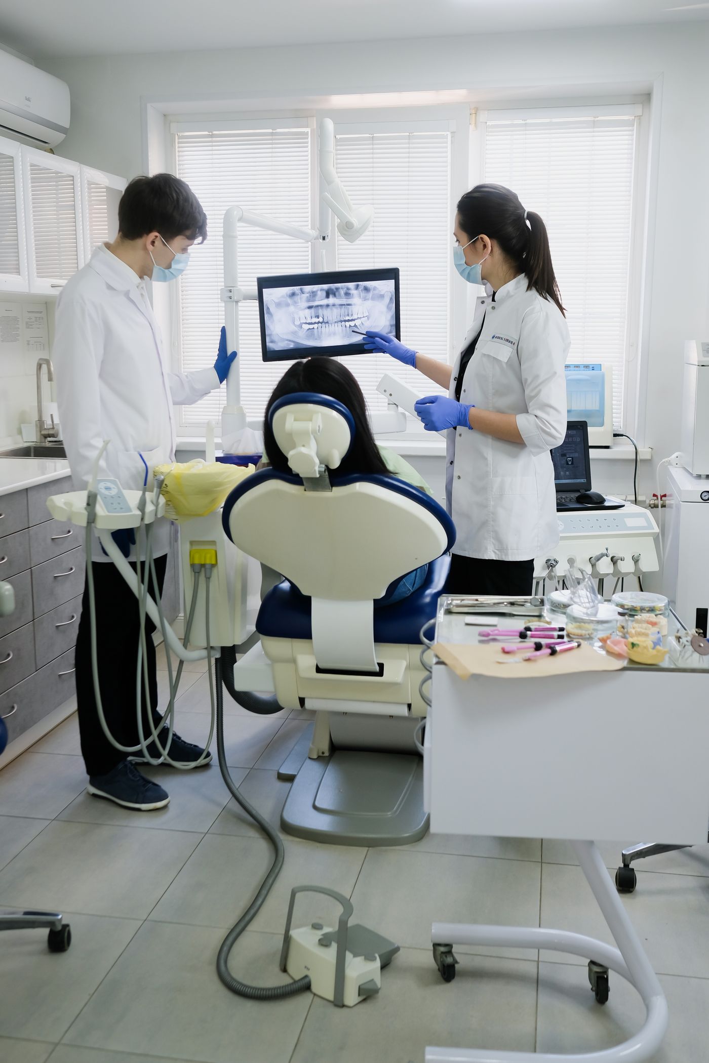 Equipo dental atendiendo a una paciente en el gabinete