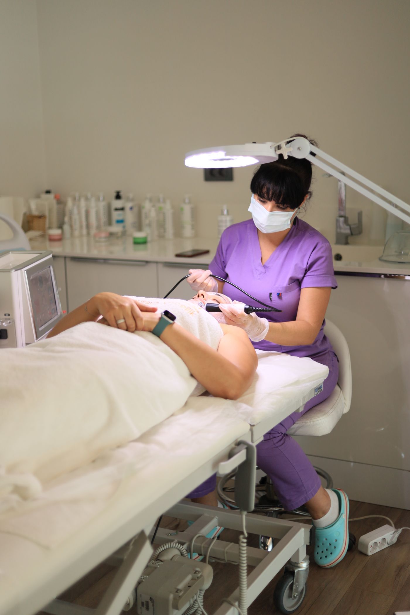 Profesional realizando un tratamiento facial en una cabina de estética